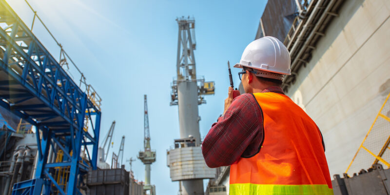 Projektsteuerung Mann steht auf der Baustelle mit dem Rücken zur Kamera gerichtet